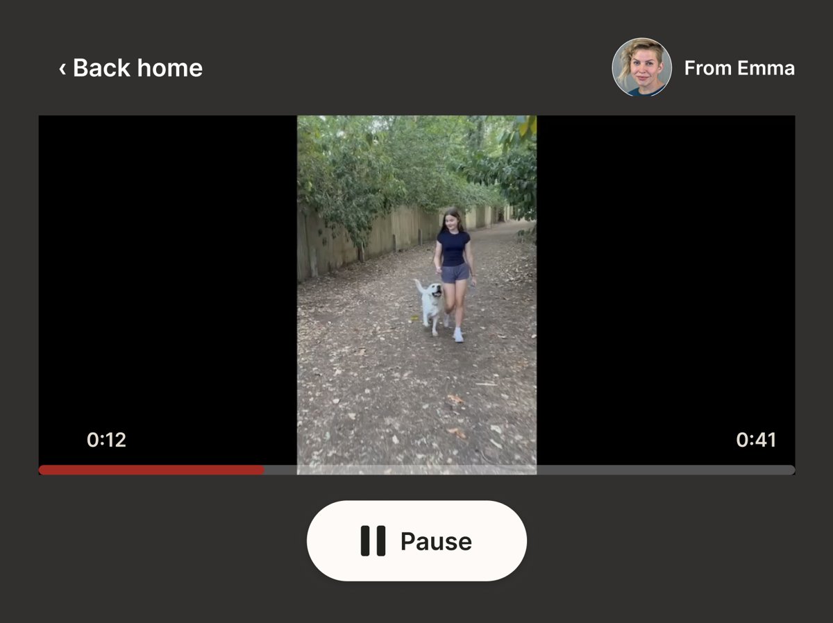 A Family Bridge session on the resident's tablet: a video from Emma playing, with a large Pause button